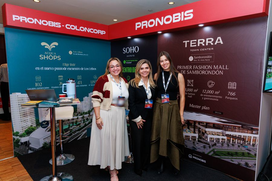 Three exhibitors smiling at a real-estate developer booth in a congress trade show