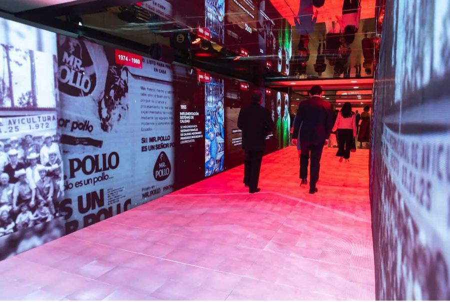 Guests walking through an immersive red LED tunnel at a corporate anniversary event
