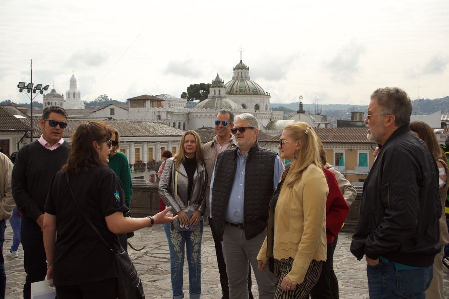 Local guide leads a group on a rooftop overlooking Quito's historic domes and churches