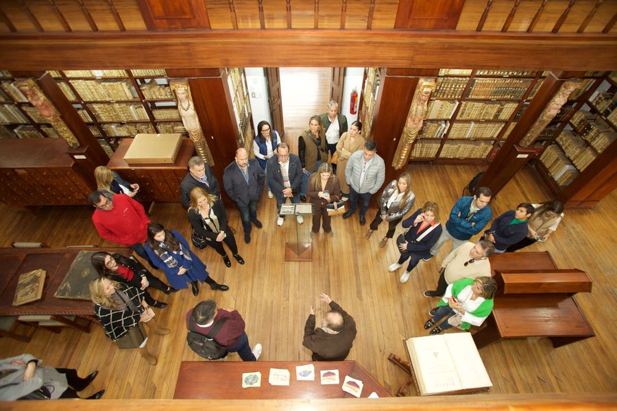 Overhead view of a corporate group touring a historic colonial library in Quito