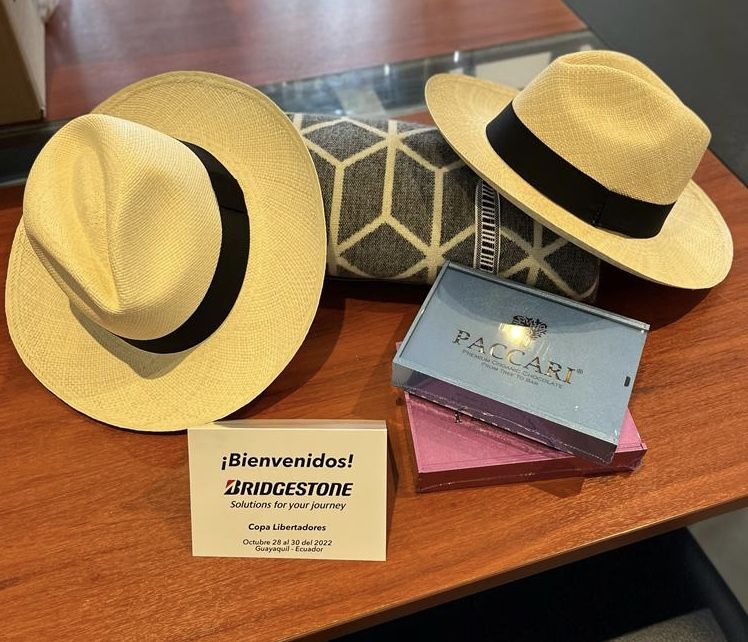 Panama straw hats, woven blanket and Paccari chocolate boxes arranged as a corporate welcome kit