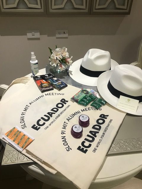 Alumni meeting welcome kit with Panama hats, printed tote bags, chocolates and fresh flowers