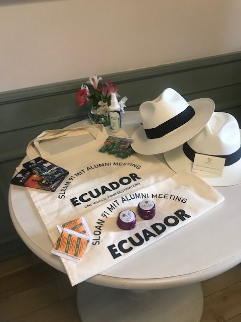 Round table displaying Panama hats, Ecuador tote bags, artisan chocolates and flowers as welcome gifts